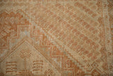 Distressed texture of a vintage Afshar rug with copper and dusty blue stepped geometric outlines.
