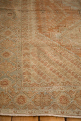 Distressed texture of a vintage Afshar rug with copper botehs and dusty blue geometric borders.