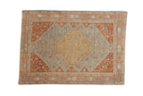 Distressed Northwest Persian rug with a stepped medallion in dusty gold, powder blue, and terracotta rust.