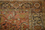 The geometric turtle samovar border of a vintage Mehrivan rug with a distressed low pile in rust and teal.