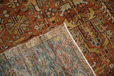 Close-up of the distressed Mehrivan carpet's corner showing the hand-knotted pile and woven underside.