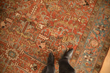 Mostly even wear across the low pile of a vintage Heriz rug, highlighting its brick red and sky blue motifs.