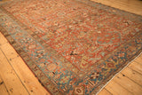 Corner perspective showing the low, even wear and geometric patterns of a vintage Heriz carpet.