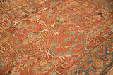 Angled view of a vintage Heriz carpet's turtle samovar border and intricate geometric field.