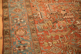 Close view of the vintage Heriz carpet's sky blue turtle border and adjacent brick red field.