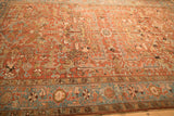 Angled view of a vintage Heriz carpet highlighting the low pile and turtle samovar border.