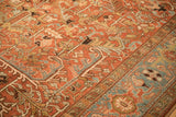 Angled detail of a vintage Heriz carpet's low pile, showing serrated leaves and the sky blue turtle border.
