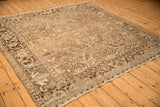 Angled view of a vintage Heriz carpet showing the turtle samovar border in beige, brown, and powder blue.