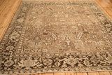 The intricate turtle samovar motif in the chocolate brown border of the distressed vintage Heriz carpet.