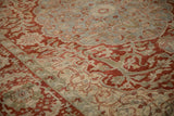 Serrated leaf and palmette motifs in pomegranate red and blue on a distressed Ahar carpet with low pile.