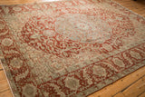 Angled perspective on a vintage Ahar carpet showing its soft, distressed texture in red and dusty blue.