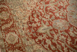 Distressed texture of a vintage Ahar carpet showing ruby red scrolling vines and dusty powder blue accents.
