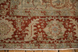 Close-up on the distressed, low-pile texture of a vintage Ahar carpet's border in red and powder blue.