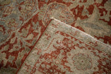 Folded corner of a vintage Ahar carpet highlighting its time-softened pile and secured edge.