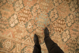 Panelled blossoms and cypress trees on a distressed Bakhtiari carpet with a low, even-worn pile.