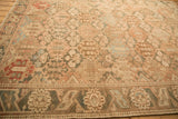 Low perspective across a distressed Bakhtiari carpet, showing the even wear on its hand-knotted pile.