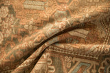 A fold reveals the low, even pile and hand-knotted texture of a distressed Bakhtiari carpet.