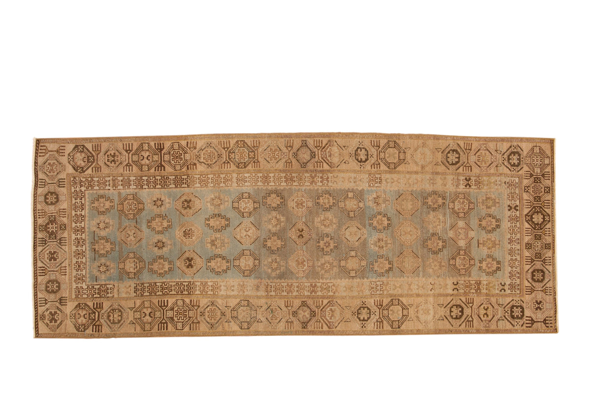 Vintage Hamadan rug runner with repeating geometric guls on a dusty blue field and a wide beige border.