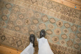 Overhead view of a distressed Hamadan runner's geometric pattern in soft blue and beige tones.