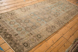 Angled view of the distressed Hamadan runner showing its repeating geometric guls and even, low pile.