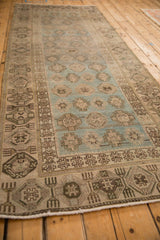 Low angle view of the distressed Hamadan runner's repeating geometric patterns and wide borders.
