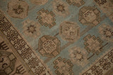 Close-up of brown geometric guls and even wear on a dusty powder blue, hand-knotted pile.