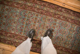 A view of the distressed texture on this vintage Karabagh runner's faded teal and raspberry pattern.