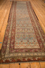 Long perspective view of a vintage distressed Karabagh runner highlighting its repeating plant motifs.