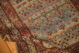 A folded corner highlights the triple border and faded colors of this vintage Karabagh rug.