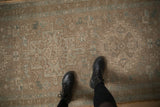 The evenly worn, hand-knotted texture of a distressed Heriz rug in beige and seafoam.