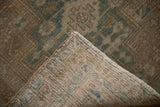 Folded corner of a vintage Heriz runner reveals the hand-knotted foundation and secured side cord.