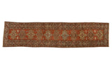 Vintage distressed Heriz rug runner with geometric medallions in brick red, sand, and powder blue tones.