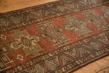 Angled view showing the repeating column of medallions on a distressed vintage Heriz runner.