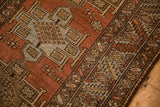 Hand-knotted texture of a distressed Heriz rug with geometric medallions and a serrated leaf border.