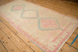 Angled view of a distressed Serab runner with geometric medallions in soft pink and sky blue.