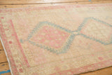 Distressed low pile texture and visible knot heads on the vintage Serab rug runner's corner.