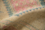 A close-up of the distressed, low-pile texture on a vintage hand-knotted Serab rug.