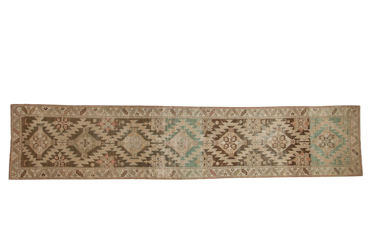 Antique distressed Karabagh runner with geometric diamond medallions in brown, sand, and dusty teal.