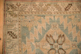 Worn texture and geometric patterns on the corner of a distressed antique Karabagh rug runner.