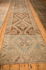 Antique Karabagh runner's geometric pattern shown in alternating dusty teal and chocolate brown color fields.