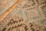 Serrated diamond medallions in dusty teal and brown on a time-softened antique Karabagh runner.