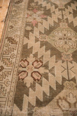 Low-pile texture and geometric guls in sand, brown, and dusty teal on an antique Armenian runner.