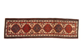 Vintage Serab Persian runner with a column of red and blue geometric medallions atop a sand-colored field.