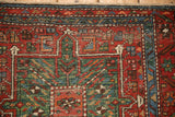 Evenly worn pile on the starburst border of a vintage Persian Karaja rug in red and blue.