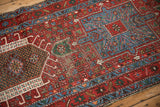 Hard wear revealing foundation among geometric floral patterns on a vintage cherry red Karaja rug.
