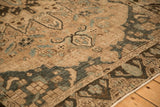 Detail of the stylized dragon border and distressed, low-pile texture of the Bakhtiari carpet.