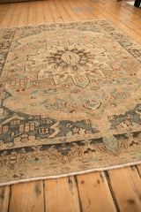 Low-angle view across a distressed Bakhtiari carpet, showing the even wear of its hand-knotted pile.