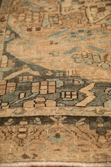 Close-up of the distressed, low pile showing the stylized dragon border in sand and blue.