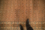 A view showing the scale of the distressed Bijar carpet's low pile, Herati field, and turtle samovar border.