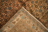 Folded corner of a distressed Bijar carpet, showing the low pile and hand-knotted reverse.